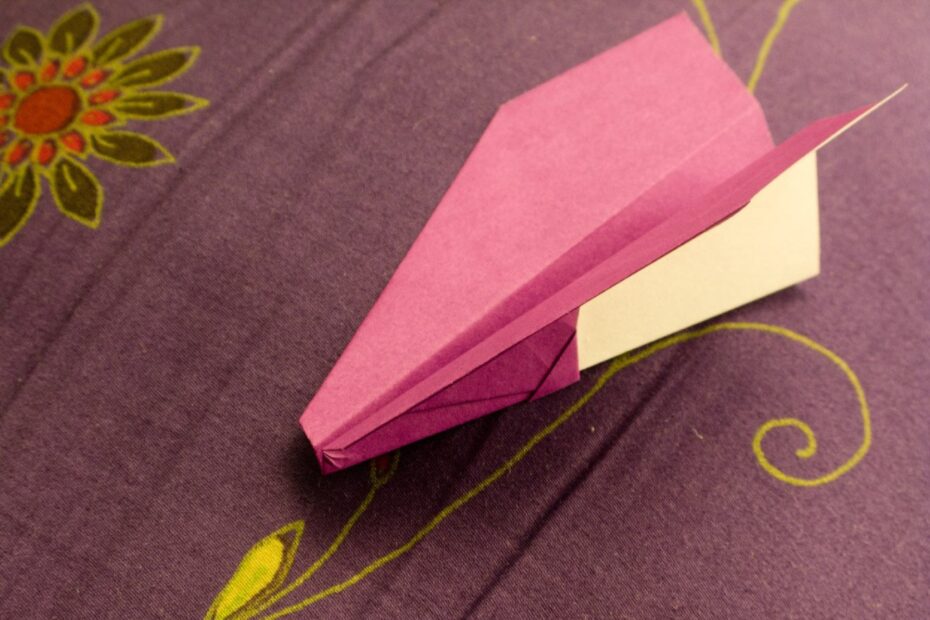 Gnat paper airplane on a patterned fabric.