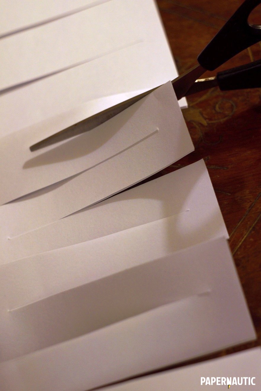 Alternating cuts in the paper from the open side between previous parrallel cuts