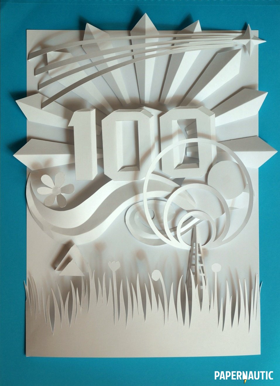 Finished paper relief sculpture in white on a blue paper background