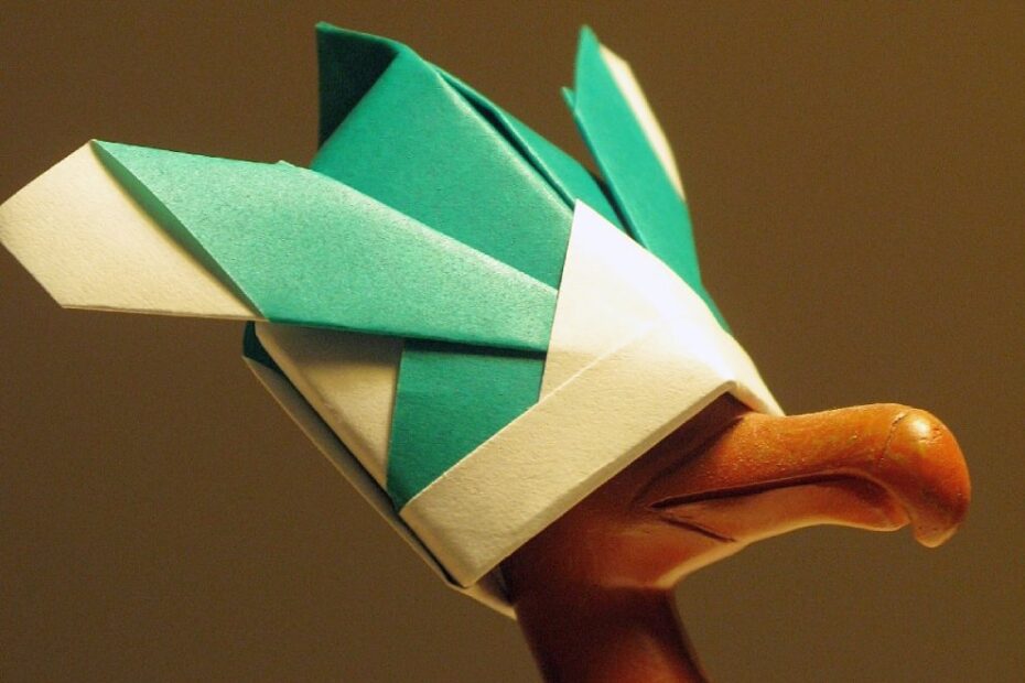 Origami samurai hat resting on the head of a small dodo statuette